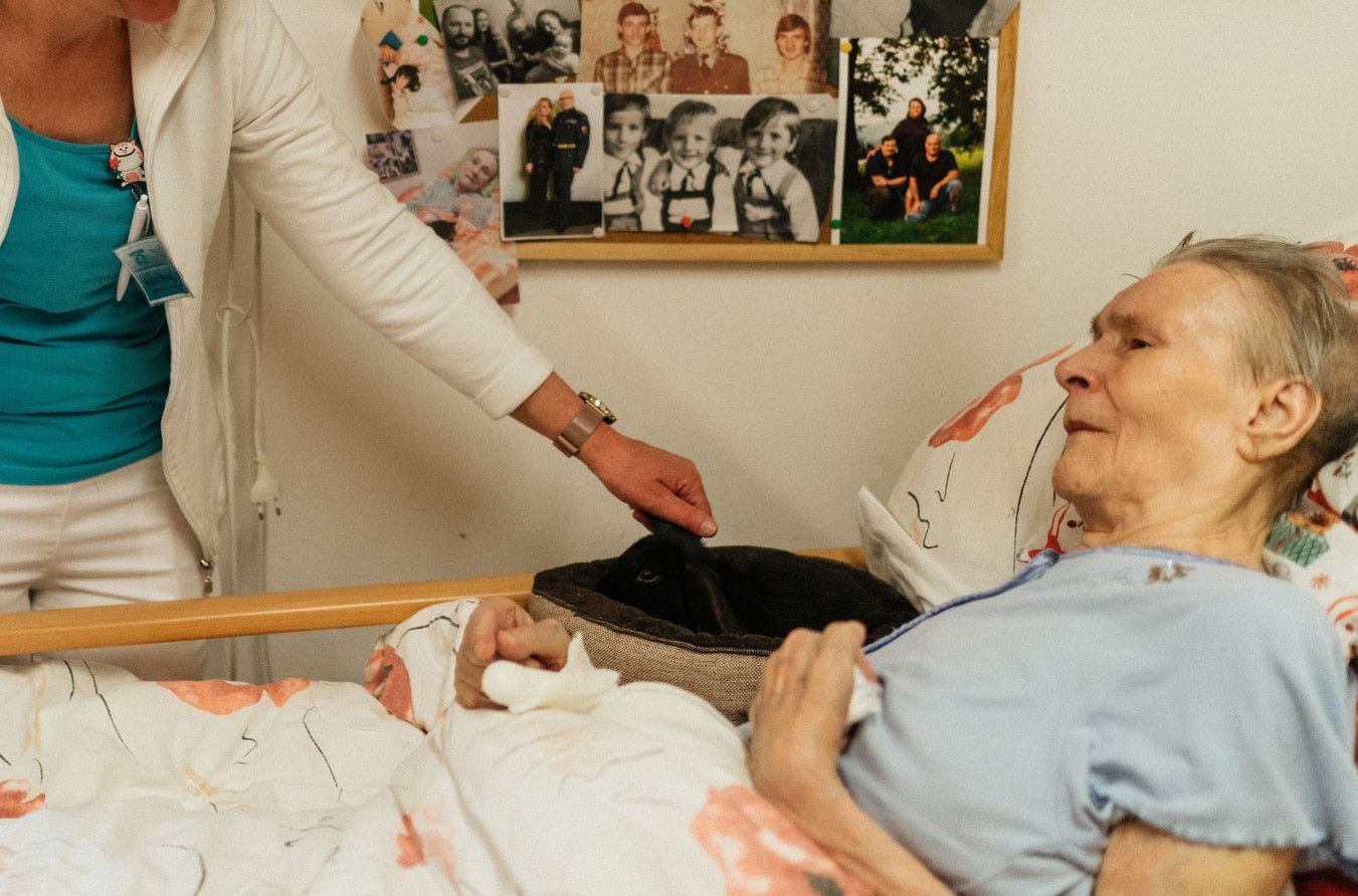 Nurse provides care for an elderly patient in a hospital room, showcasing empathy and professionalism.